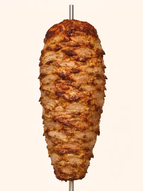 Une broche de gyros dorée sur sa tige, qui tourne au fil de la page
